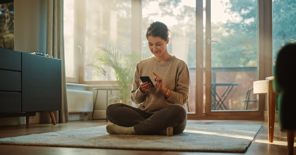 smiling young woman using smartphone