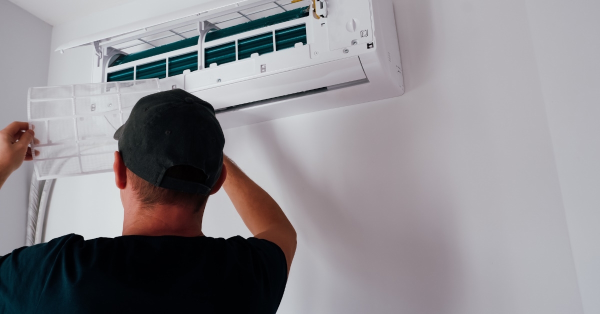 Man cleaning air conditioner filter