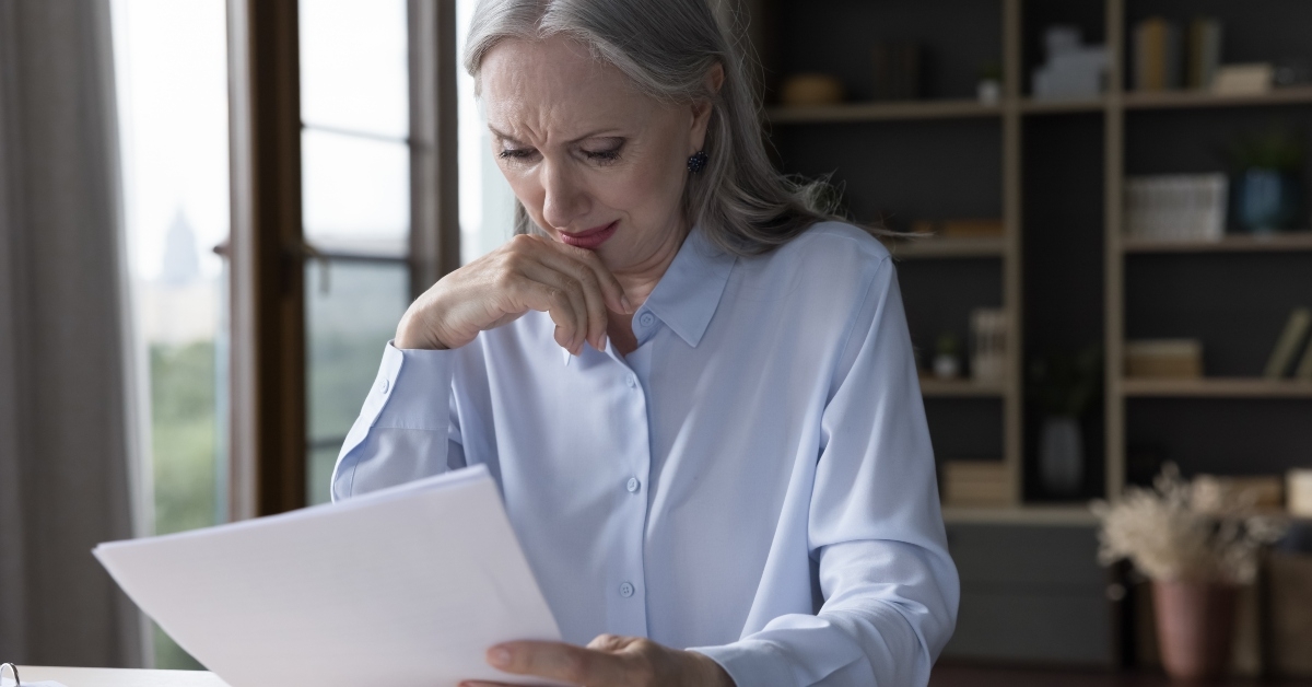 An older woman looking at a bill