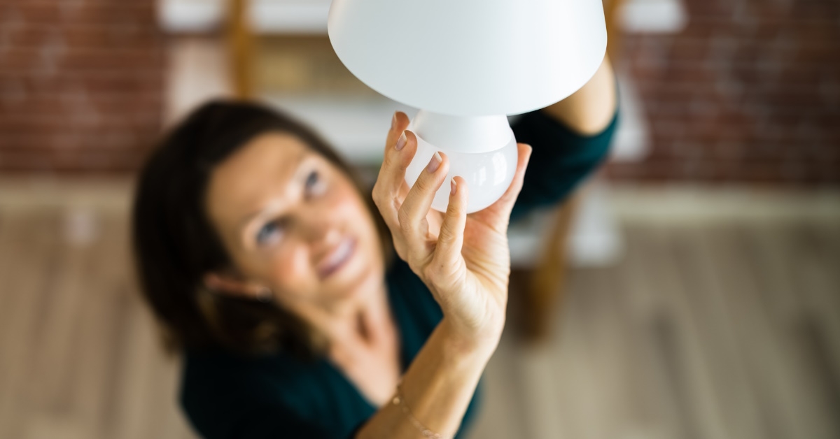 Woman changing bulb from chandelier