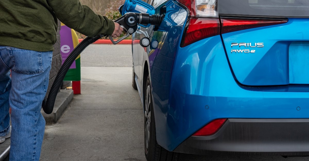 Prius hybrid car is being filled with gasoline.