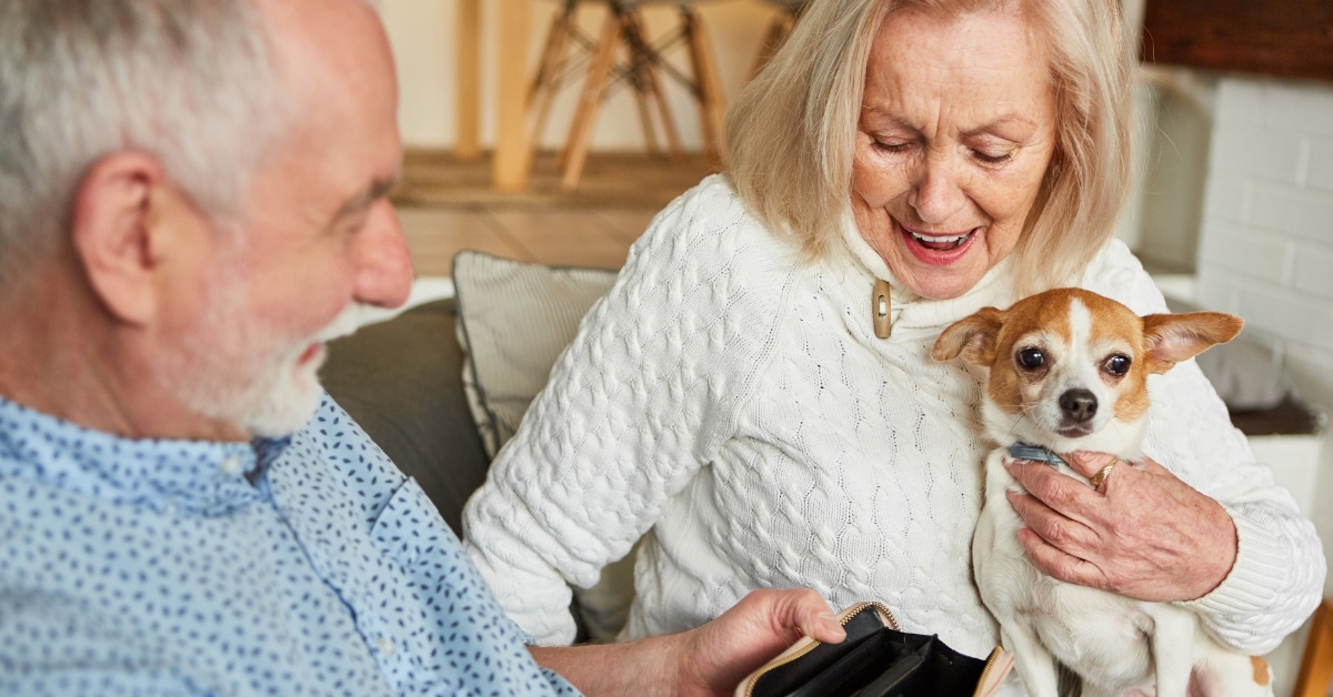 senior couple with pet checking wallet