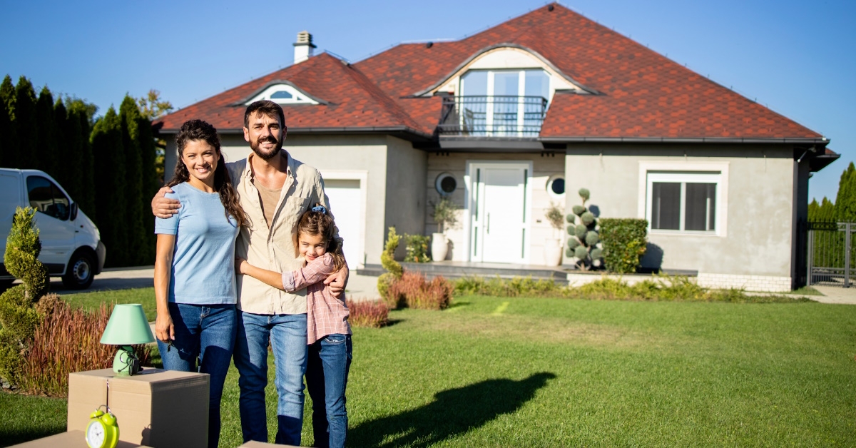 Happy family posing outside new home