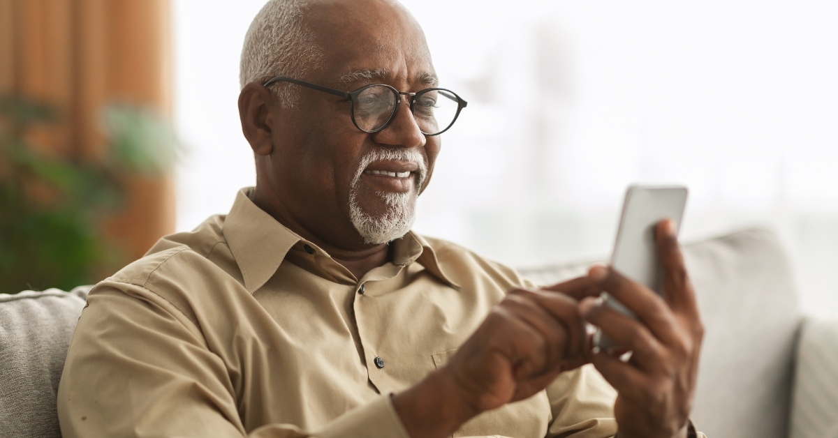 senior black man texting on smartphone