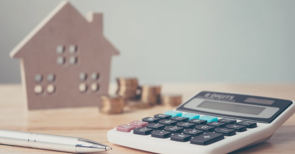 Calculator next to a small wooden home
