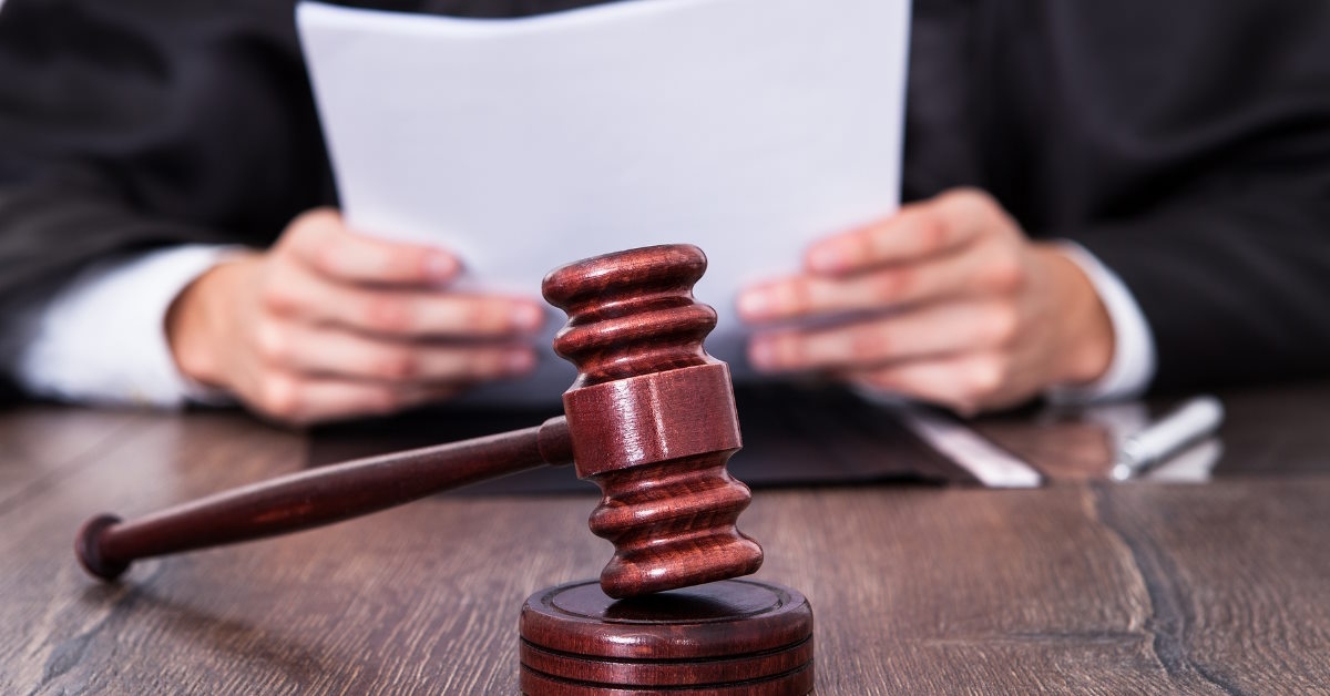 judge holding documents at table