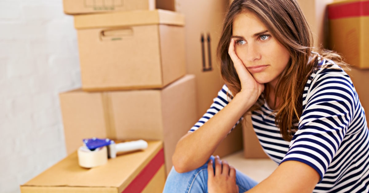 woman stressed besides moving boxes