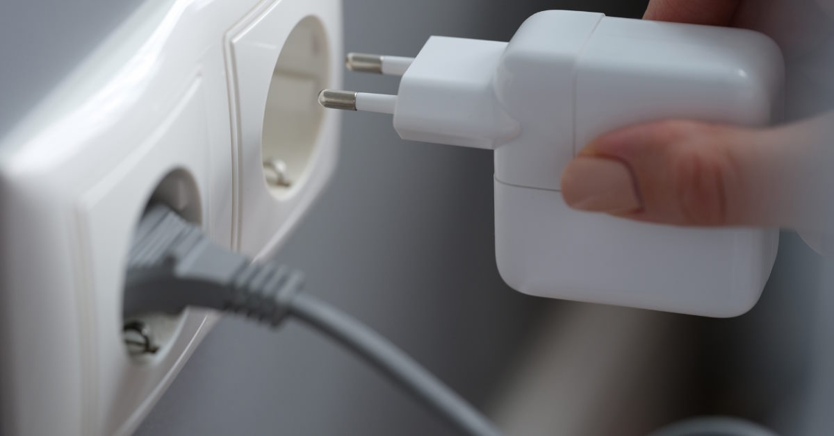 woman-plugging-adapter-in-outlet