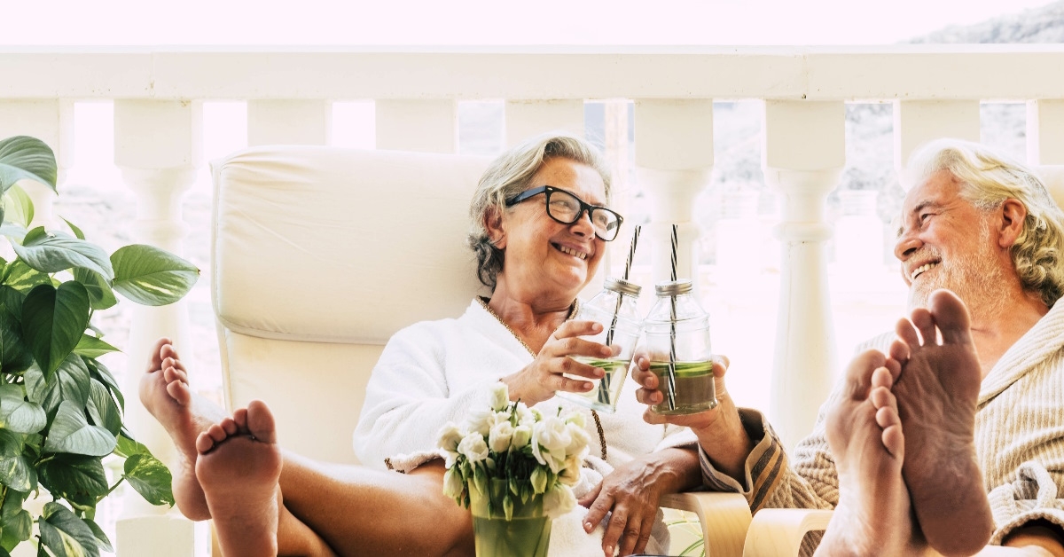 Couple drinking beverages at balcony.