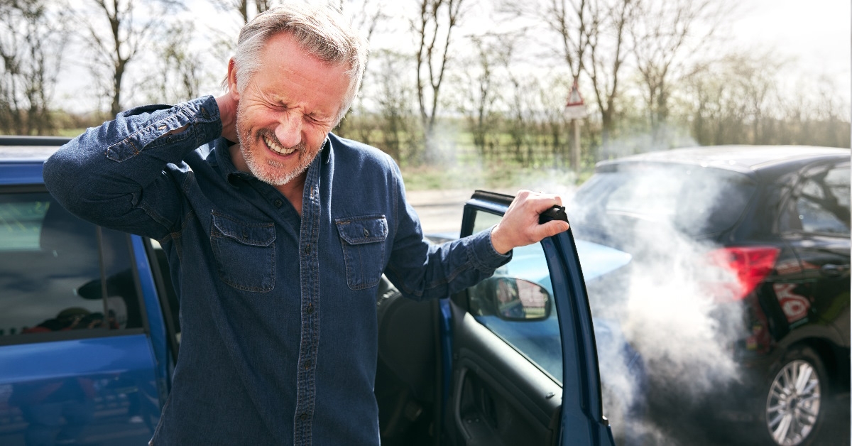 Driver stepping out of car after accident.