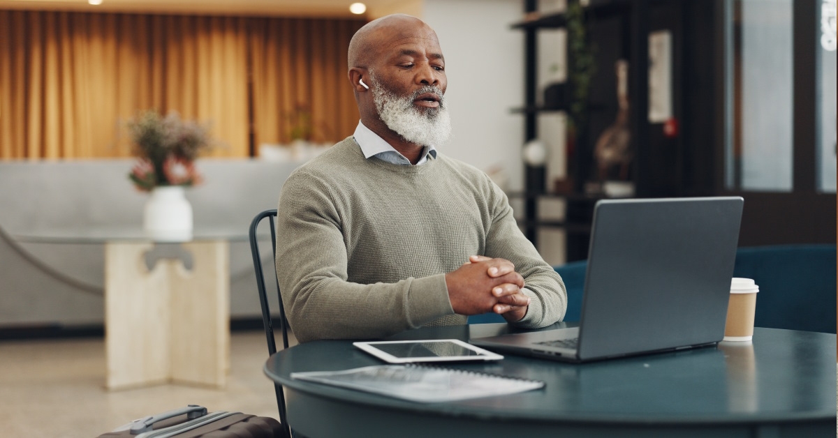 Man wearing earphones engrossed in video call.