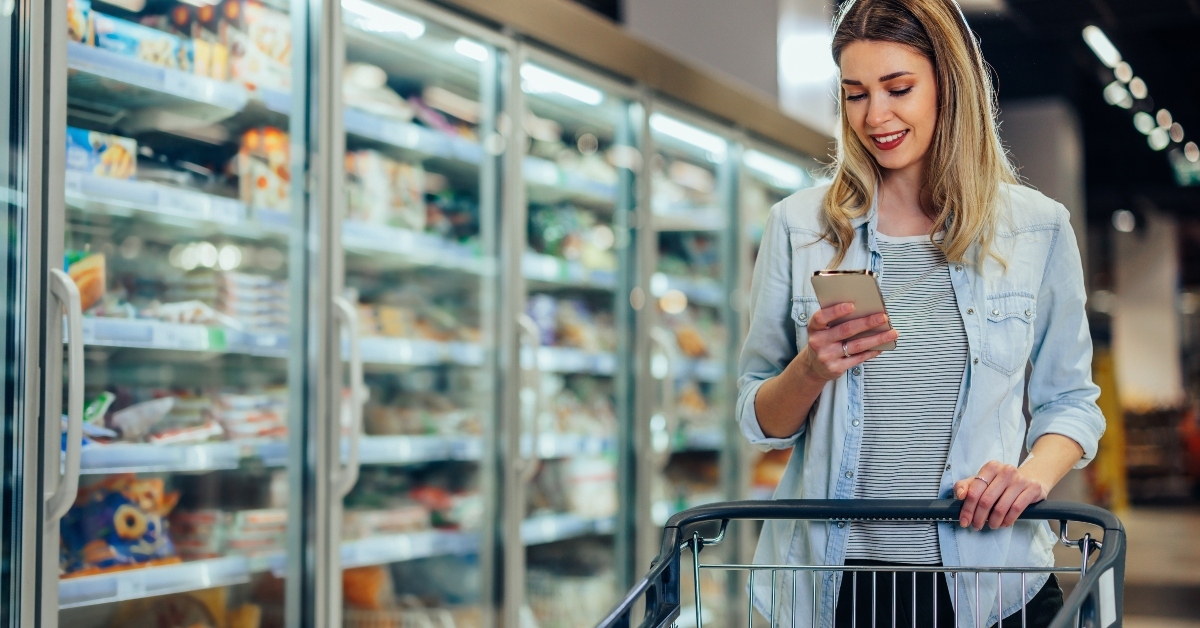 woman using phone in grocery store