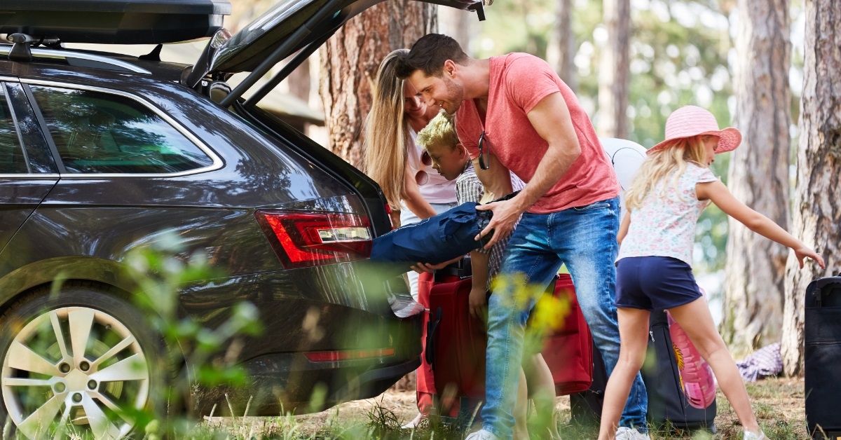 happy family loading luggage in car