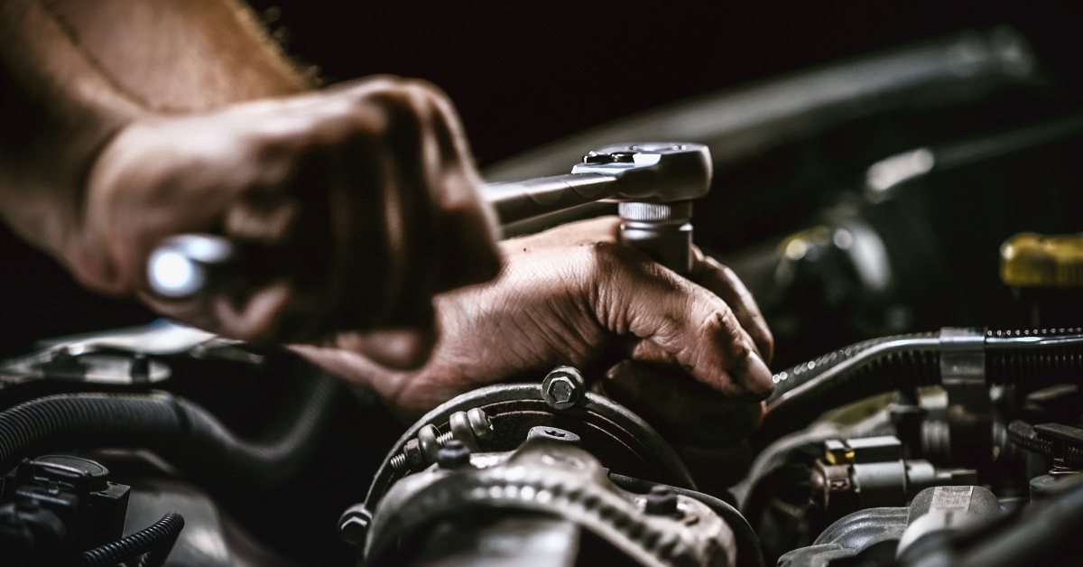 Auto mechanic working on car engine