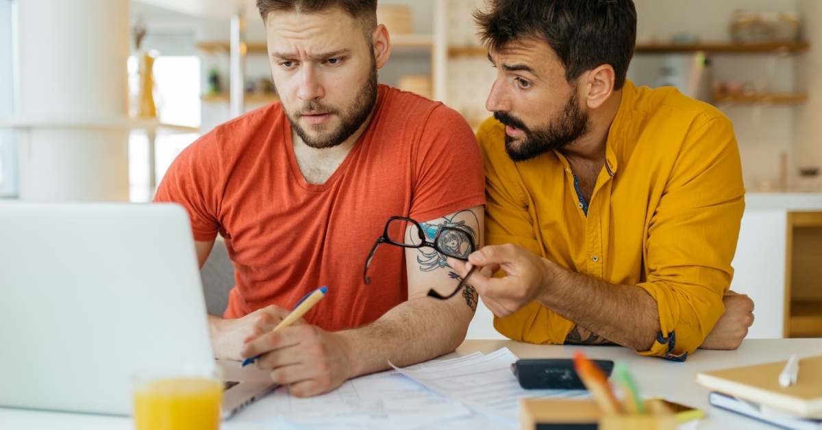 Cuple reviewing bills using laptop