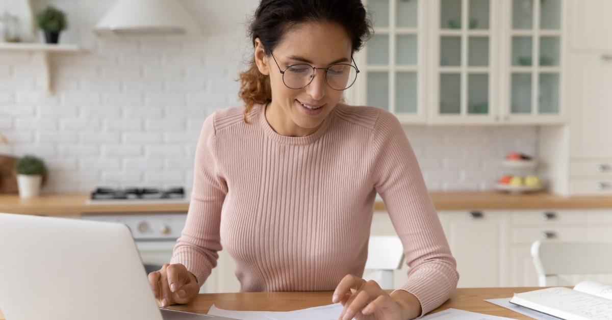 happy woman calculating bills using calculator