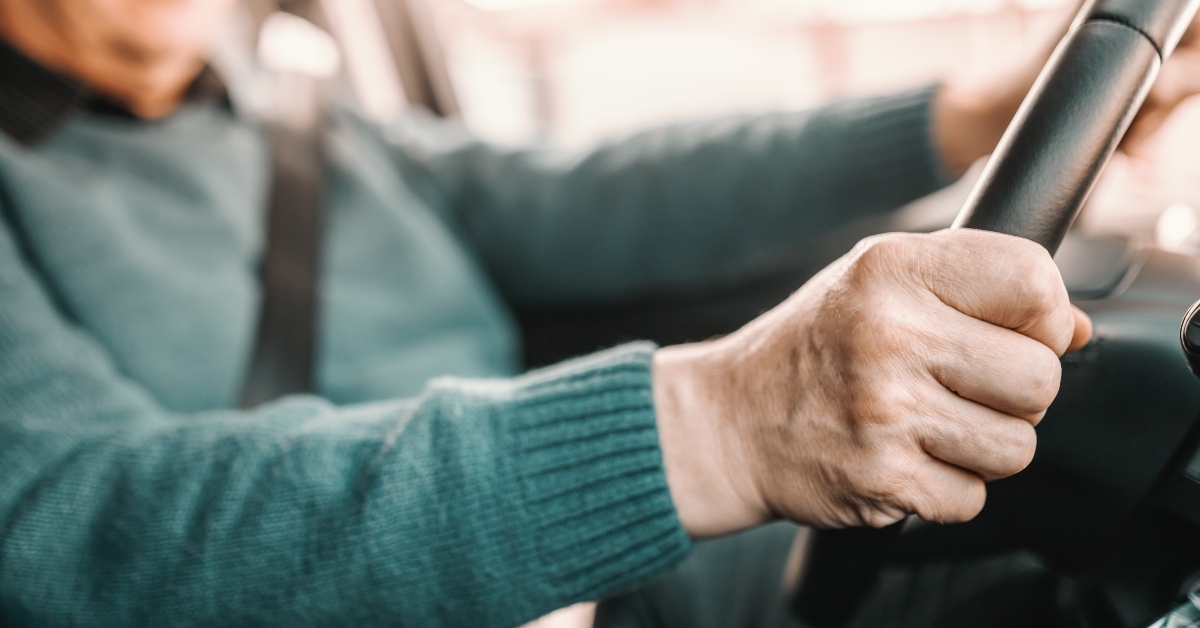 Man holding hands on steering wheel