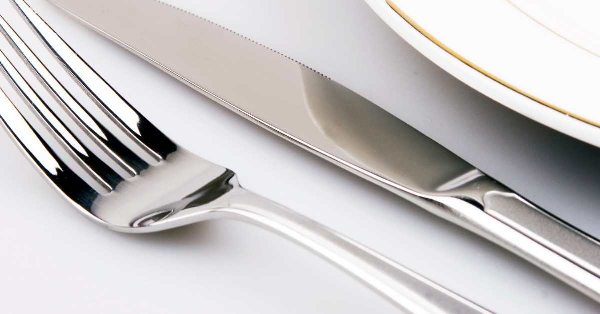 silver cutlery besides white plate