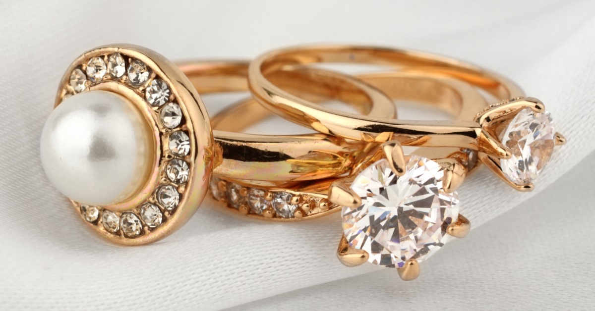 embellished gold rings on white cloth