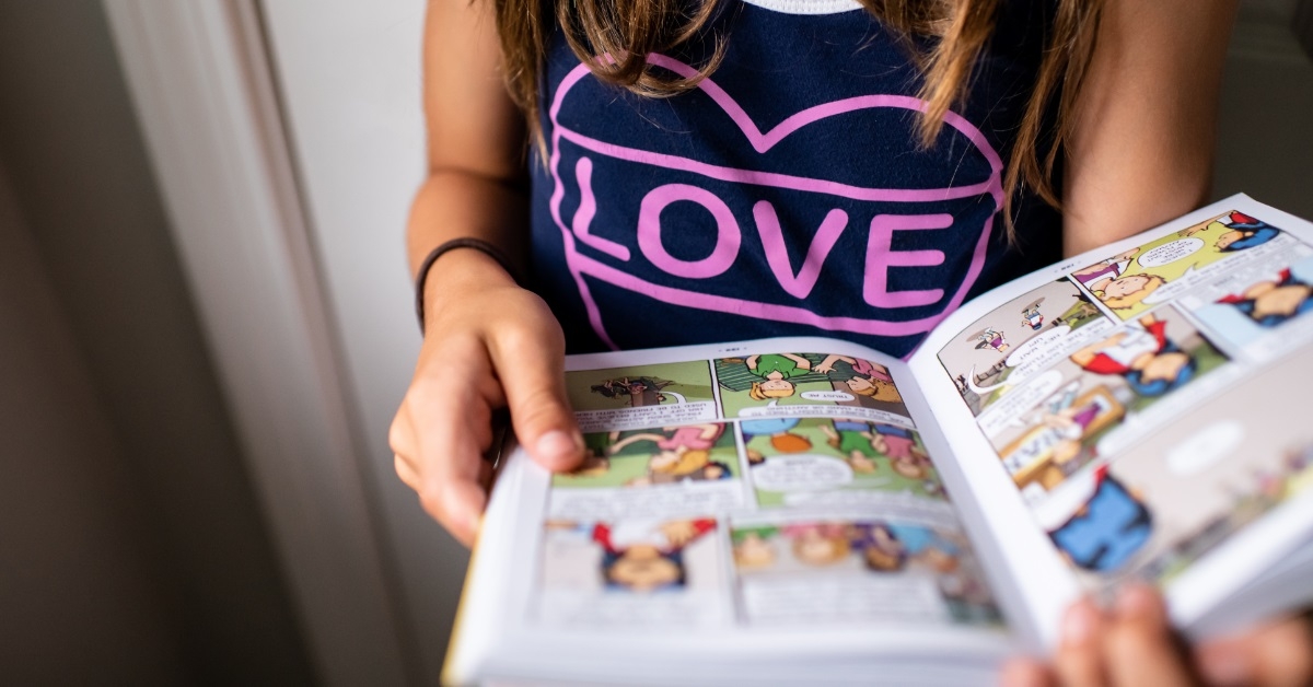 teenage girl holding comics book