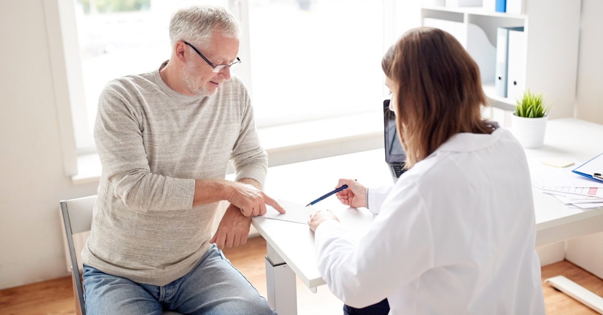 doctor giving prescription to senior patient
