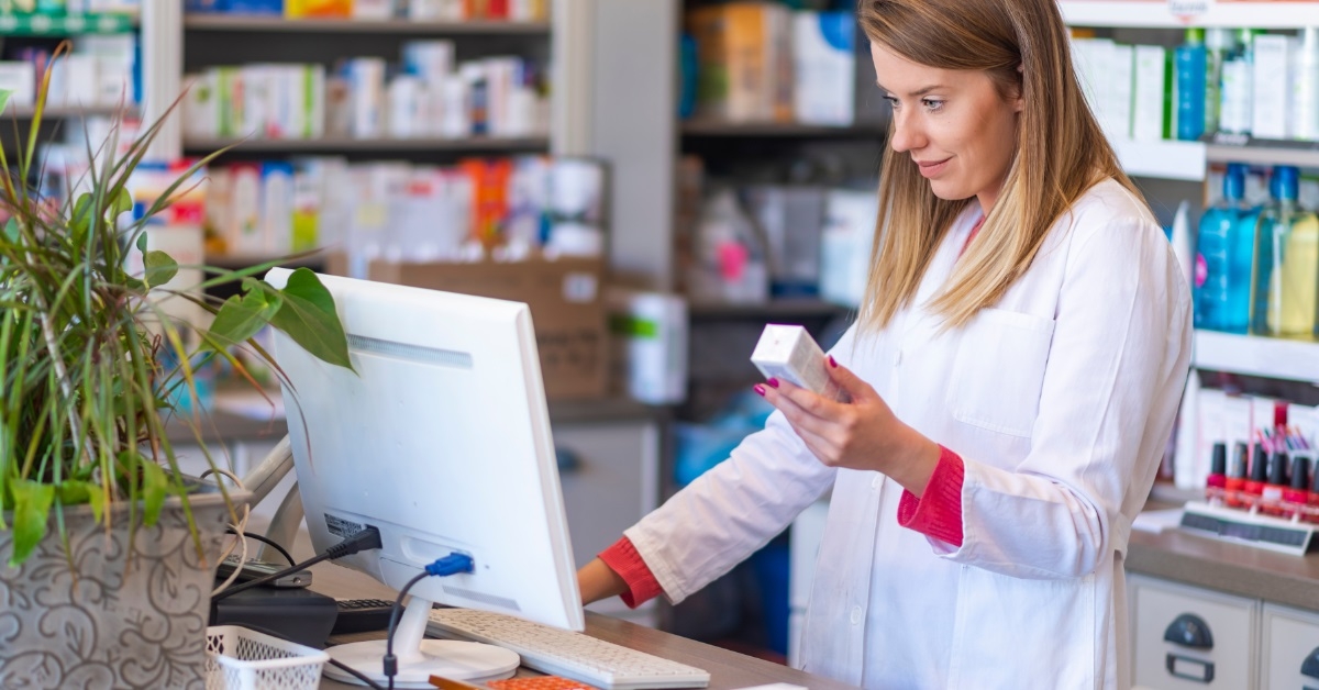female pharmacist checking medicines on computer