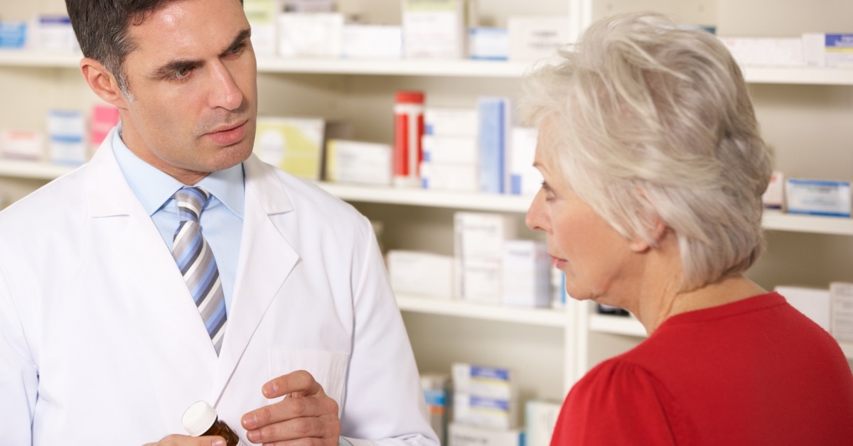 male pharmacist assisting senior woman