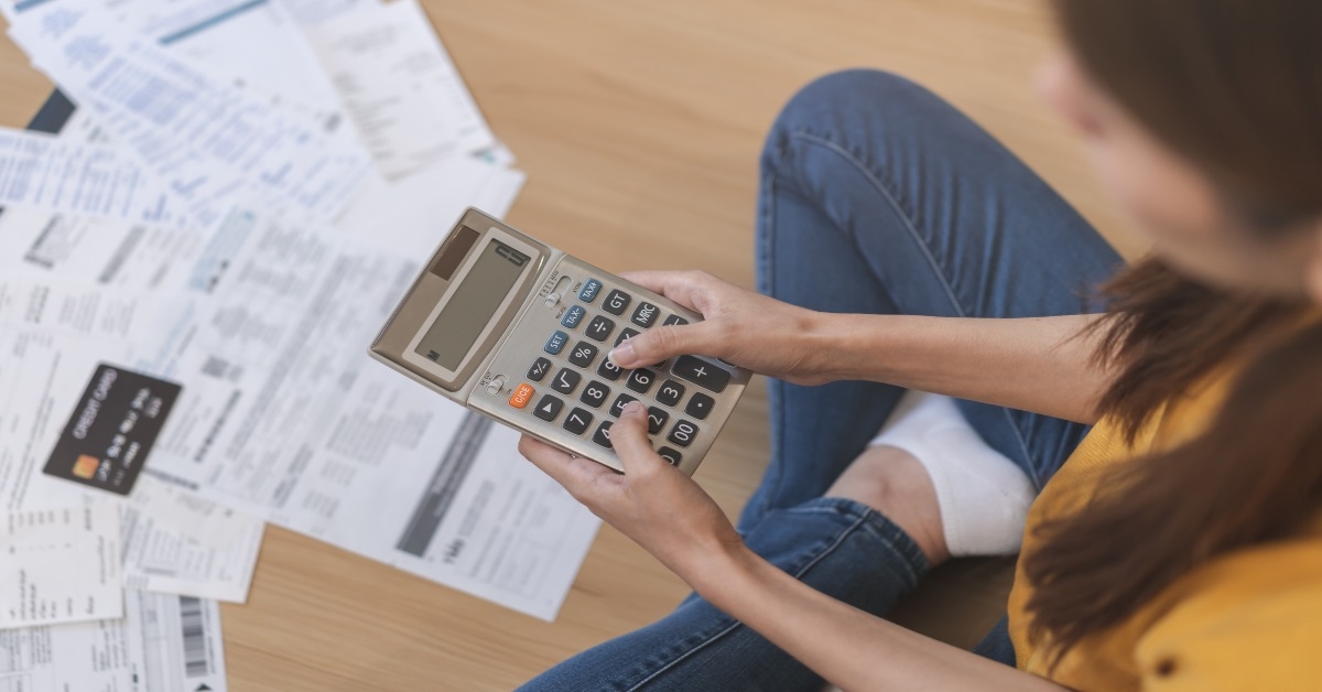 woman using calculator to review bills