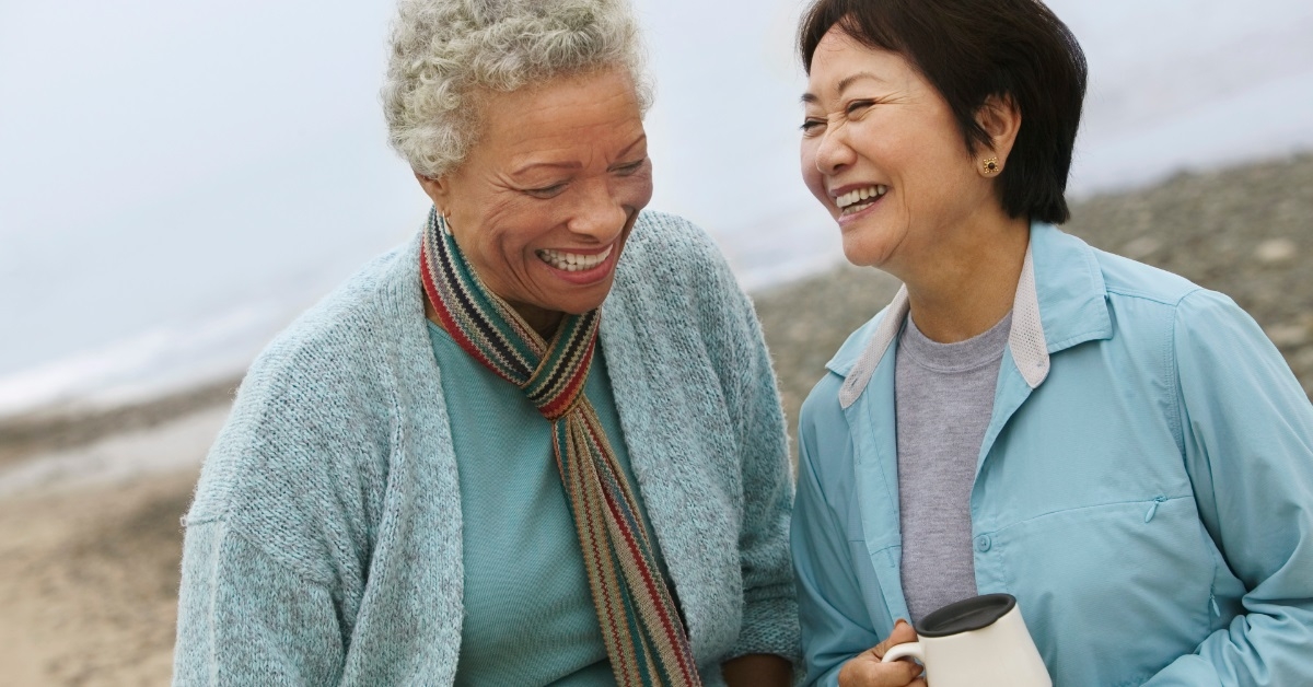 senior women enjoying coffee at beach