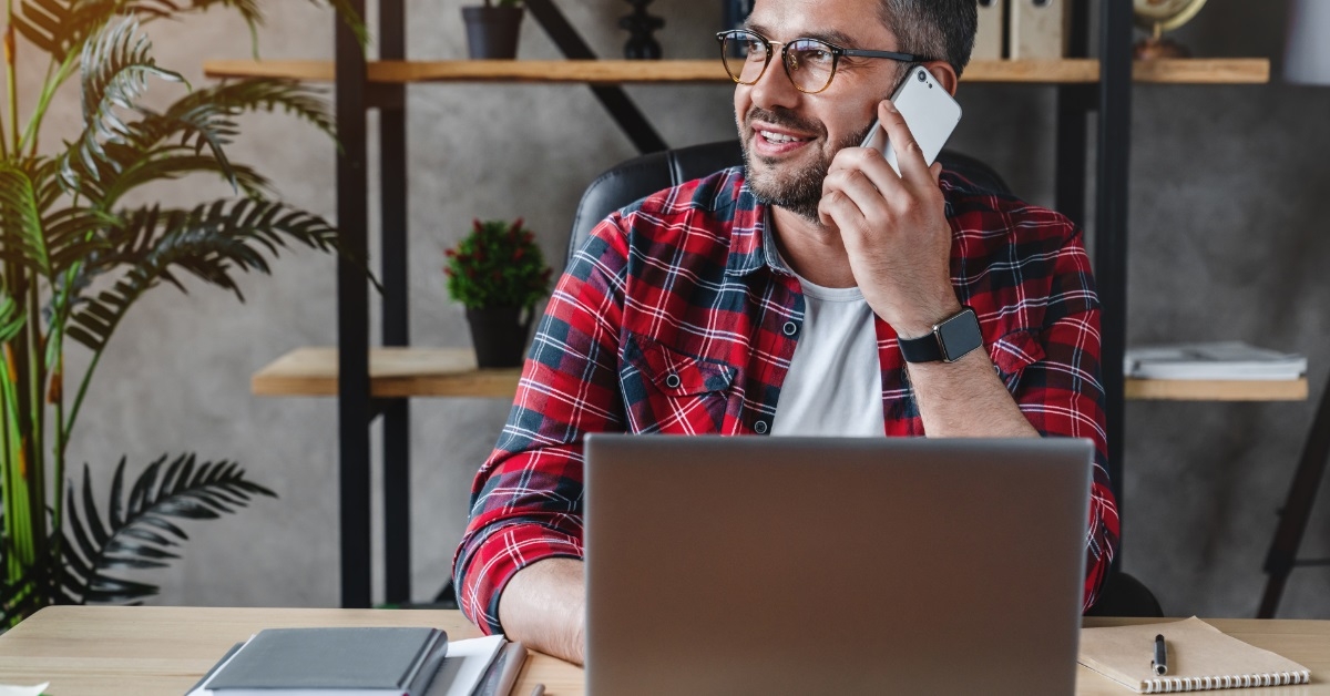 man using laptop while taking call