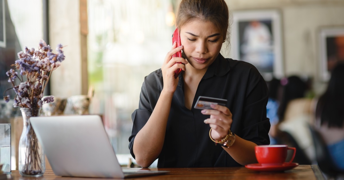 woman with card calling bank assistance