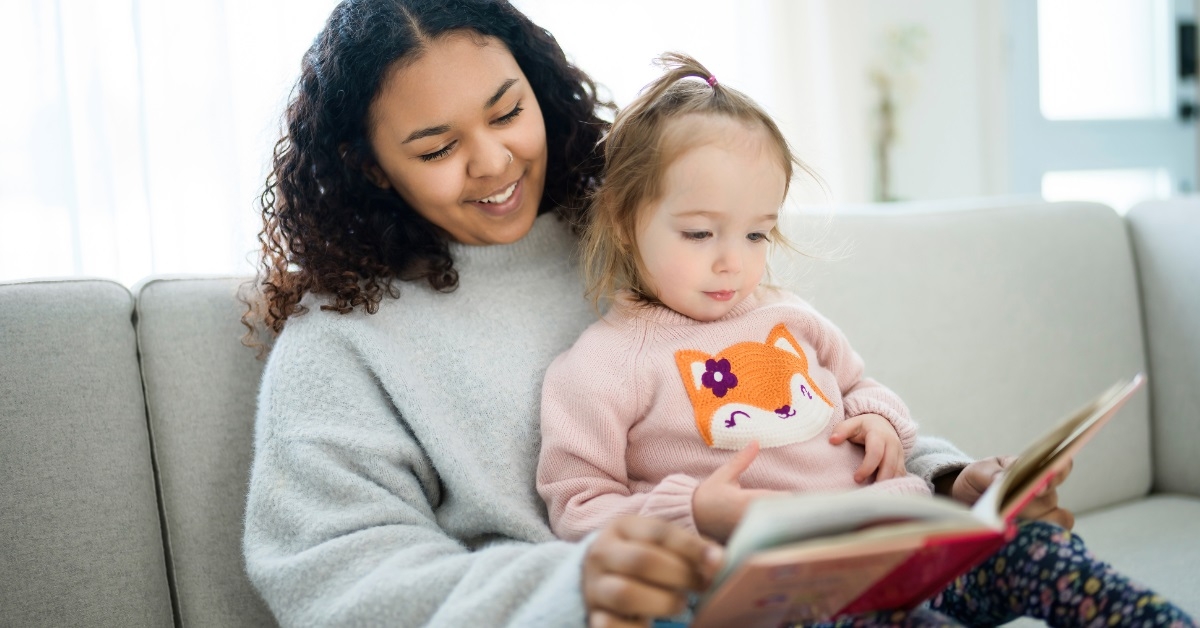 female babysitter reading book to girl