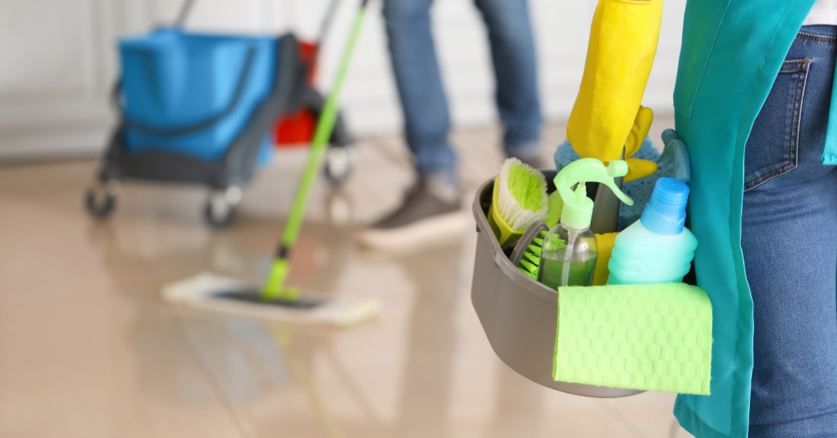 Female janitor with cleaning supplies 