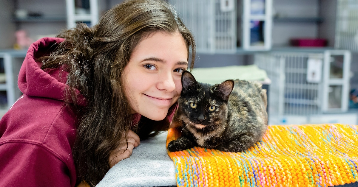 girl posing with cat at shelter