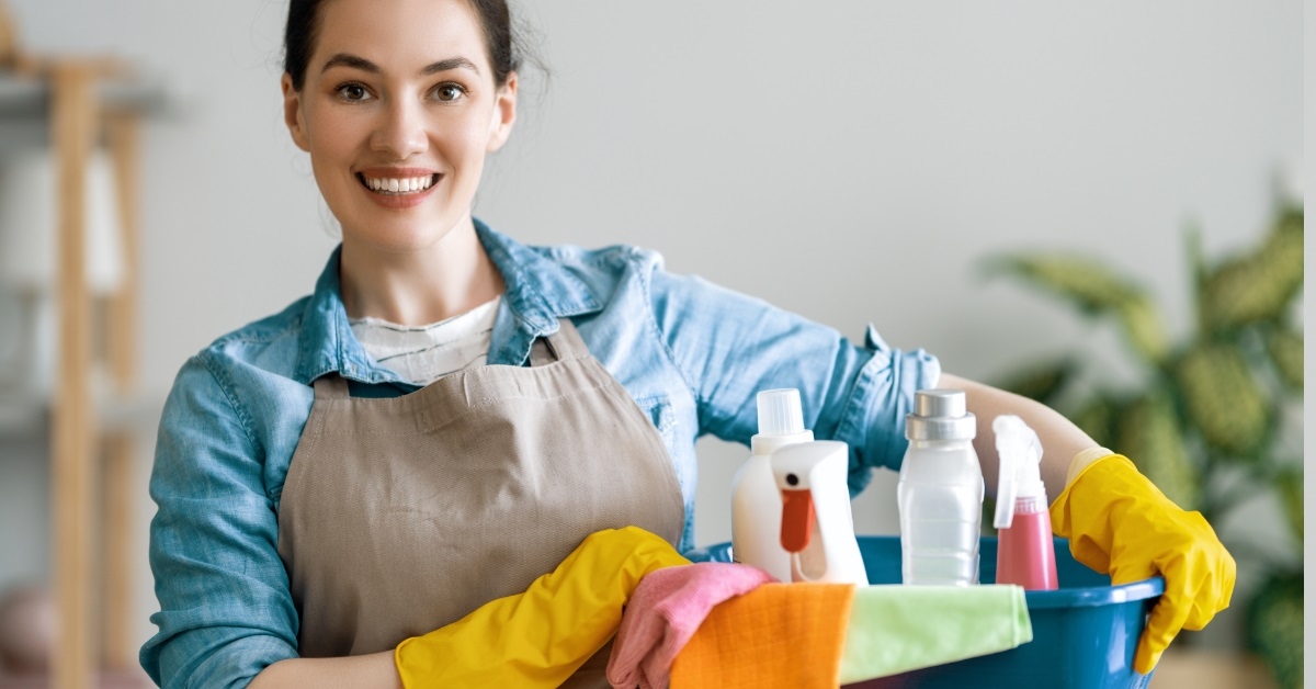woman holding bucket of cleaning supplies