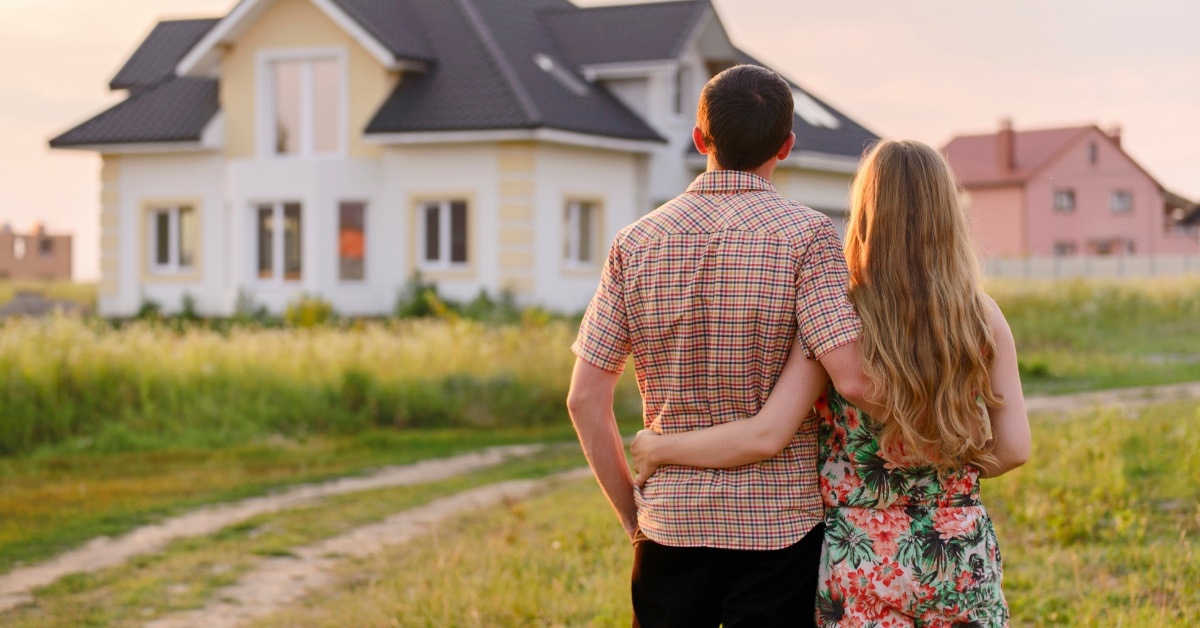 couple standing outside their new house