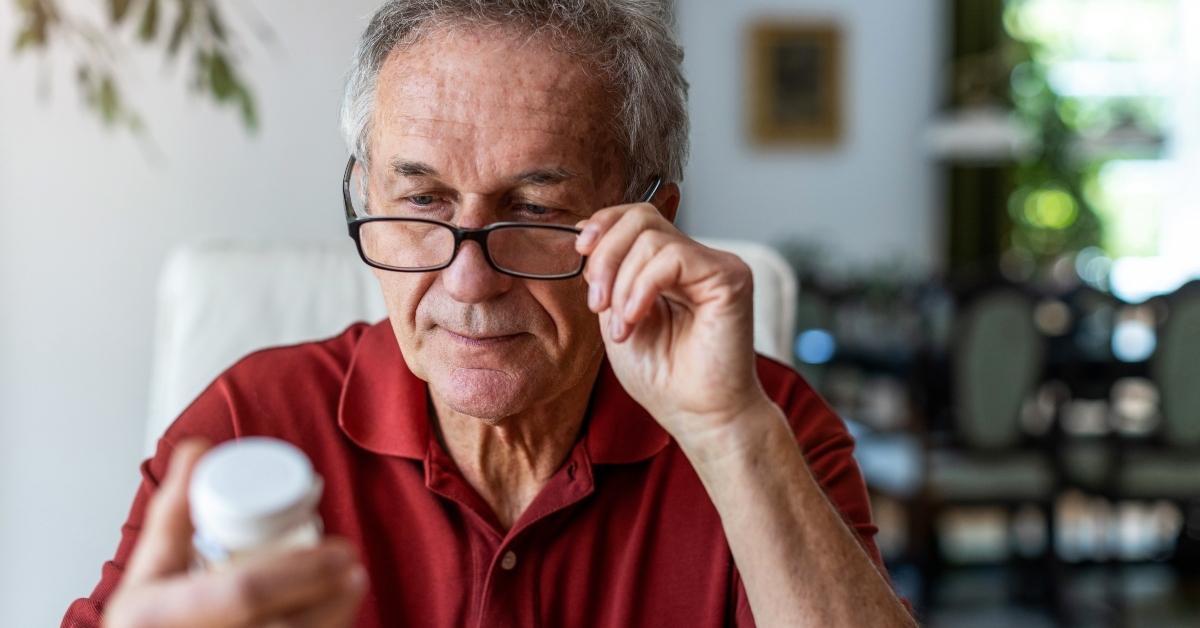 senior man taking prescription medicine