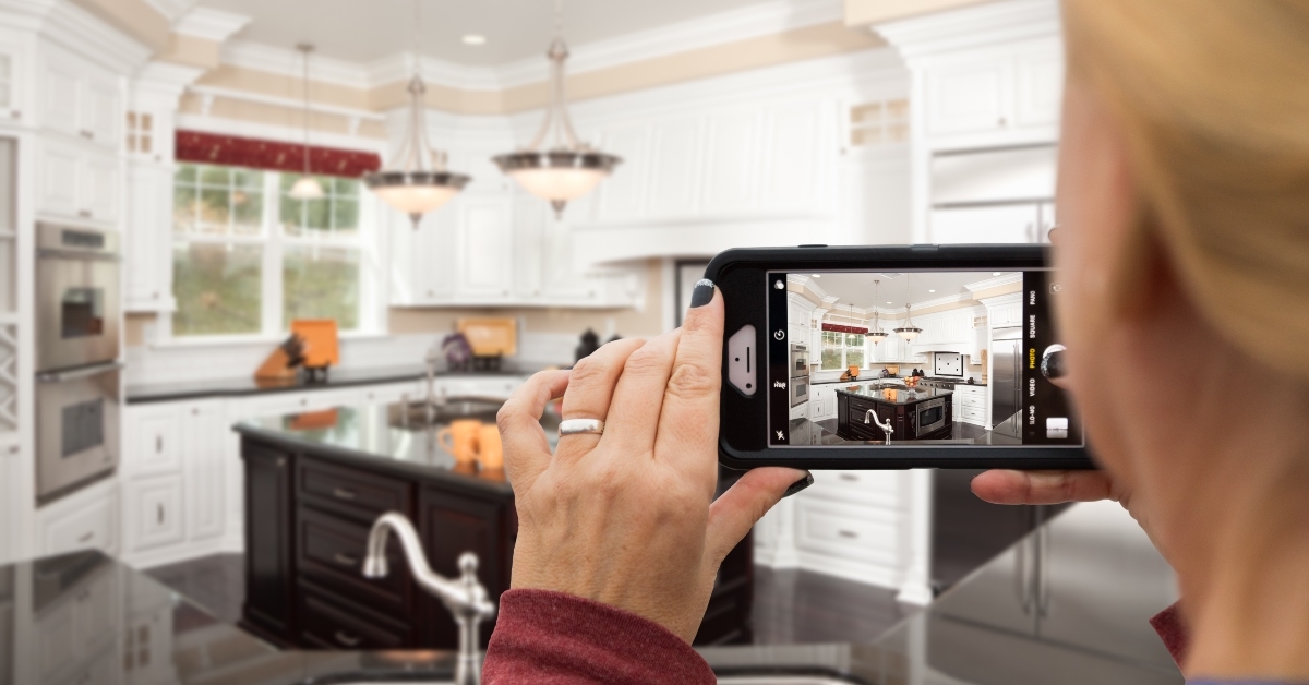 woman taking pictures of a kitchen