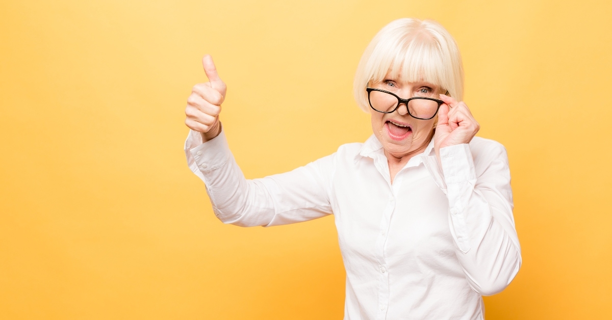 senior woman gesturing victory