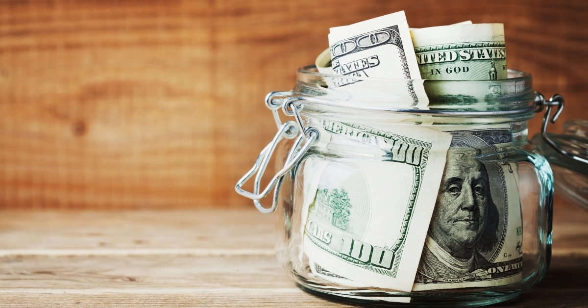 dollar bills in glass jar