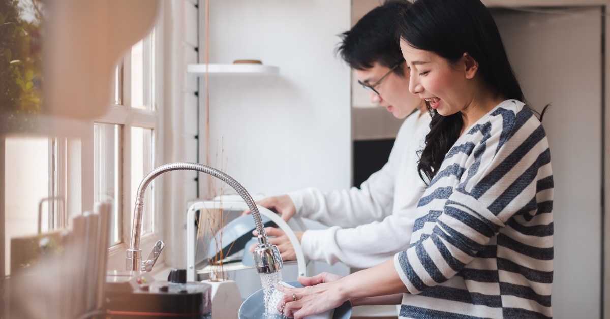happy asian couple washing dishes together