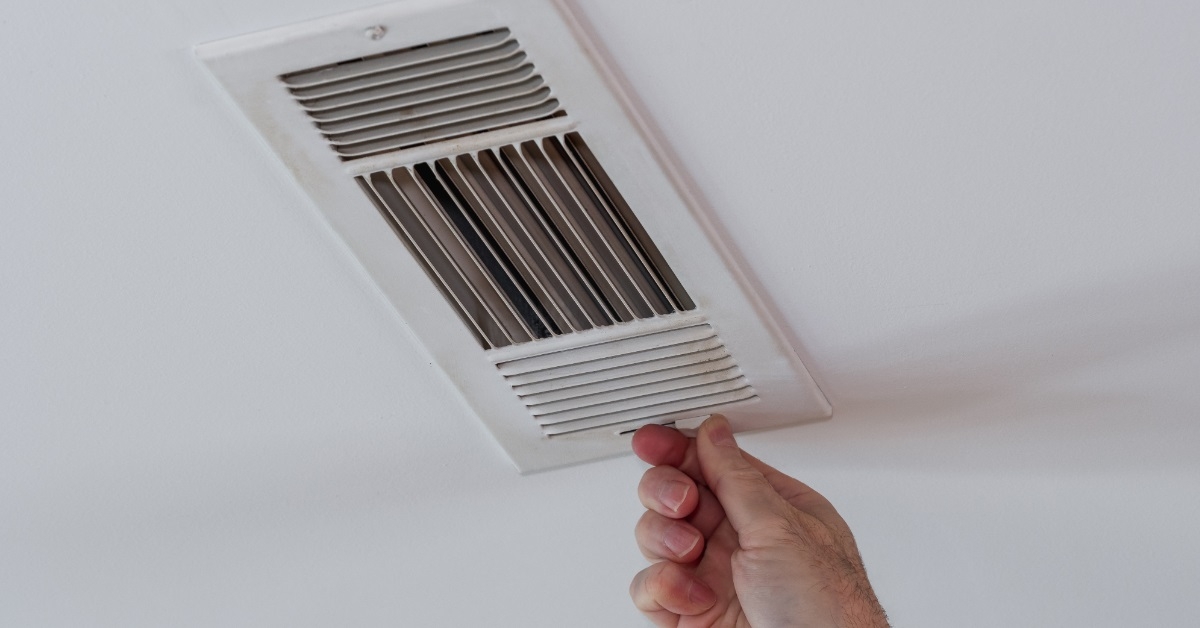 man adjusting air vent by hand