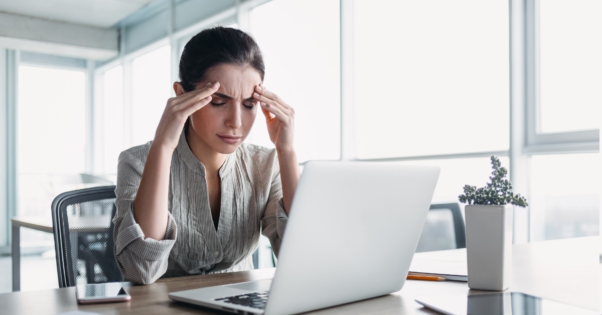 woman using laptop having headache