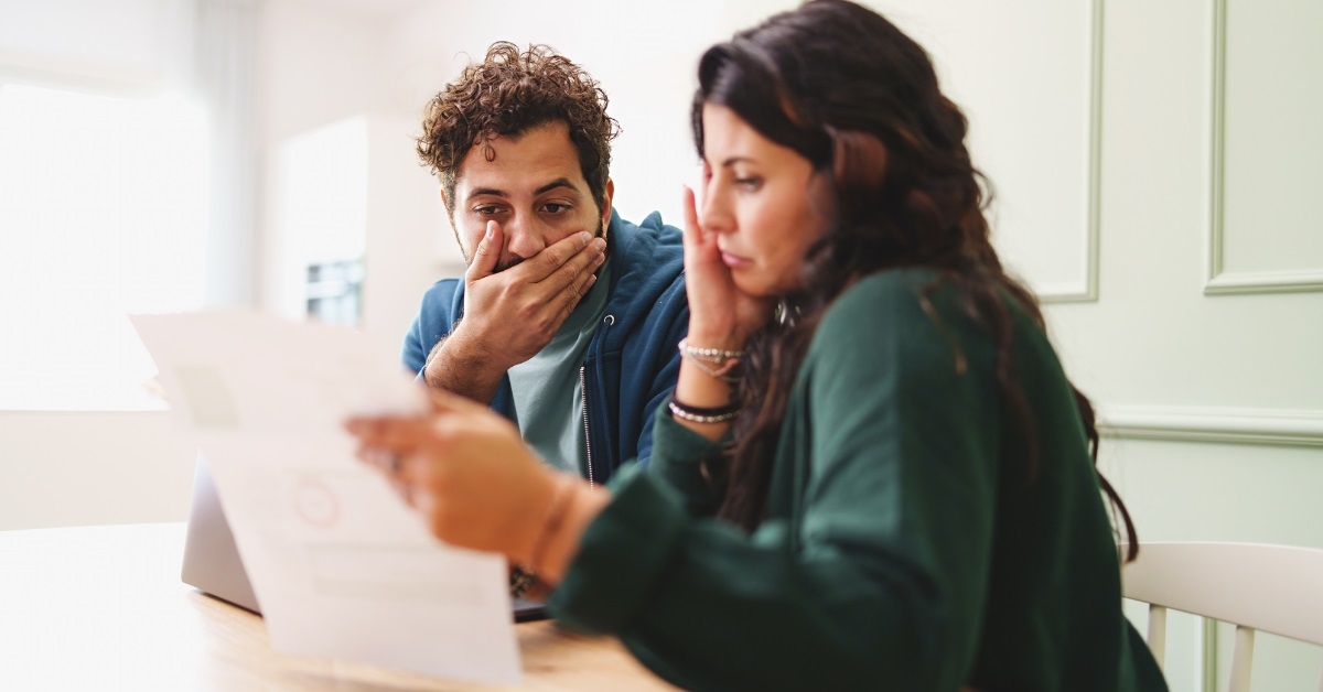 couple shocked while reviewing bills