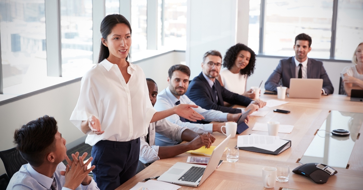 businesswoman stands to address meeting