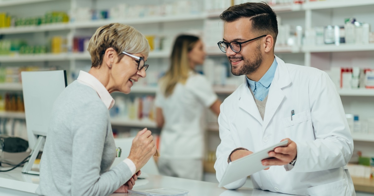 male pharmacist prescribing medicines to woman