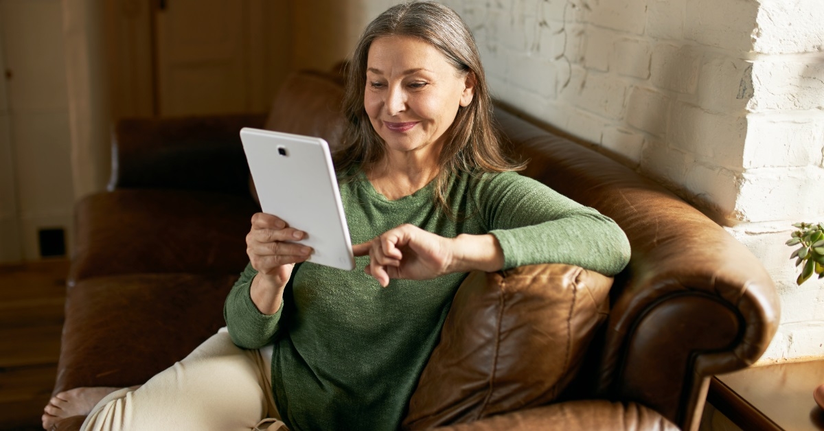 woman using tablet on couch