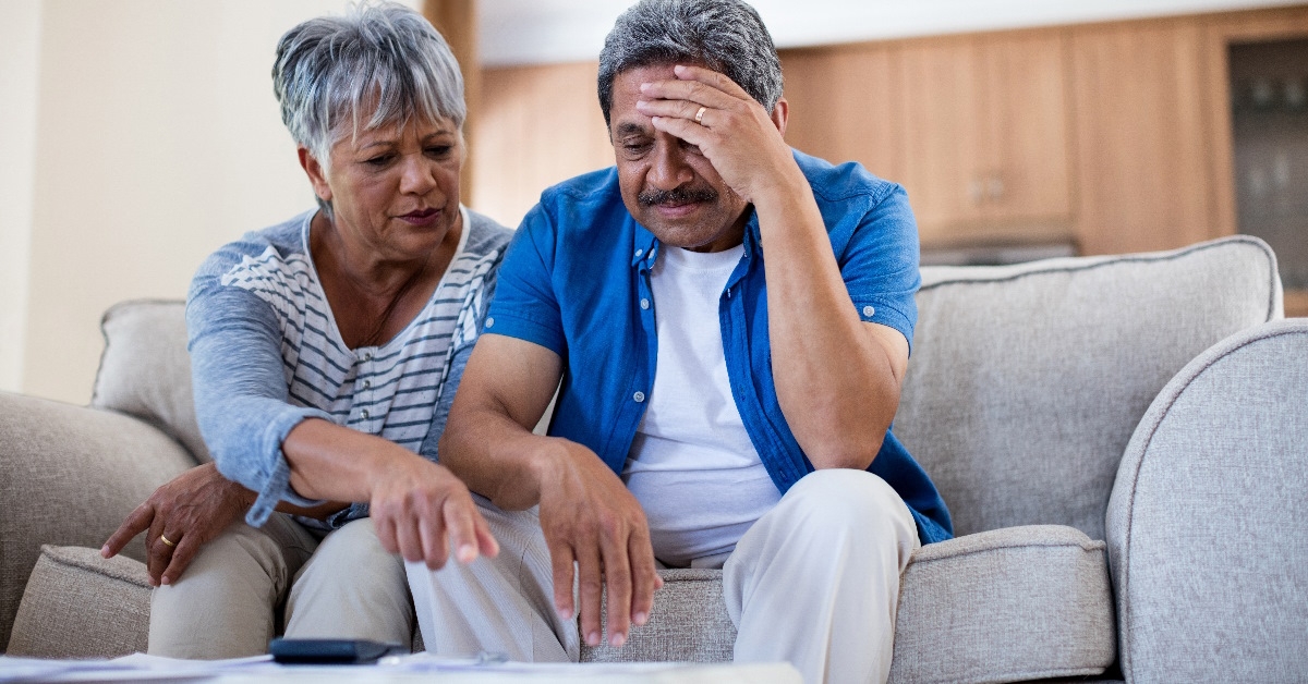 distressed older couple talking about their bill payments.