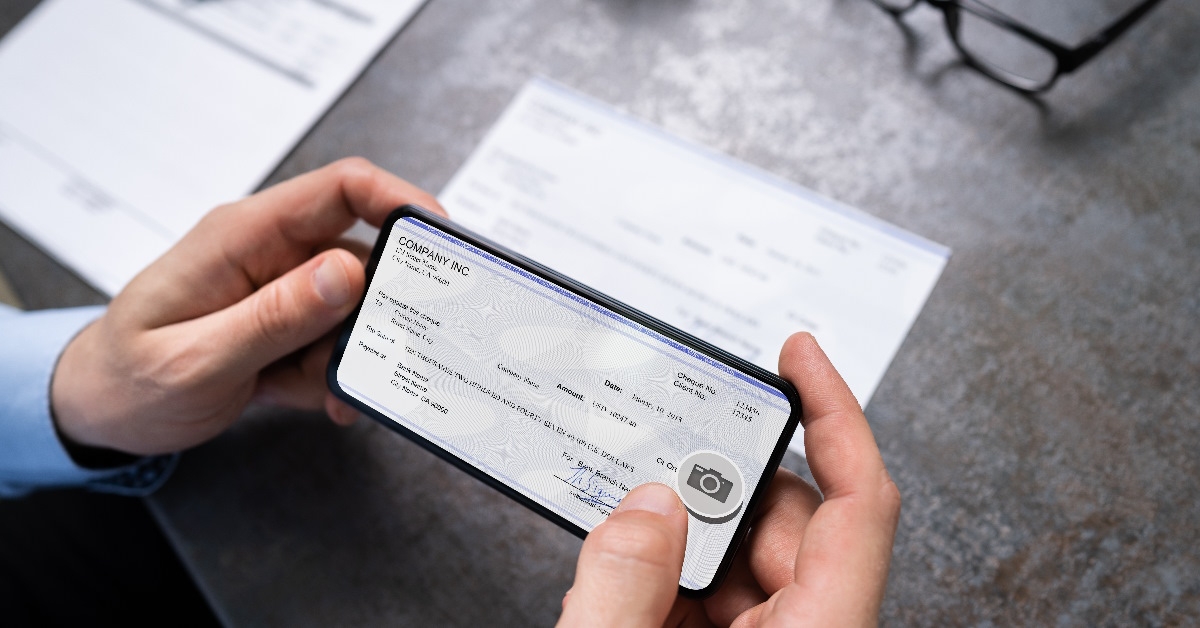A man capturing a cheque image for remote deposit.