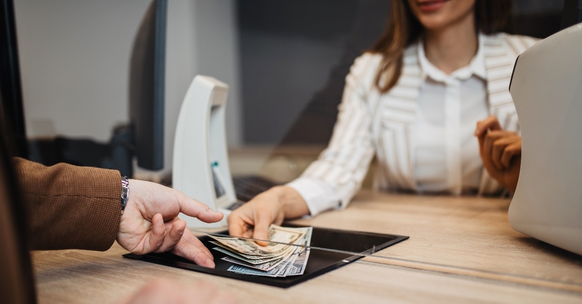 Exchange officer is giving cash money to customer.